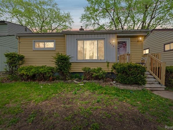Charming single-family home with a welcoming entrance and green landscaping